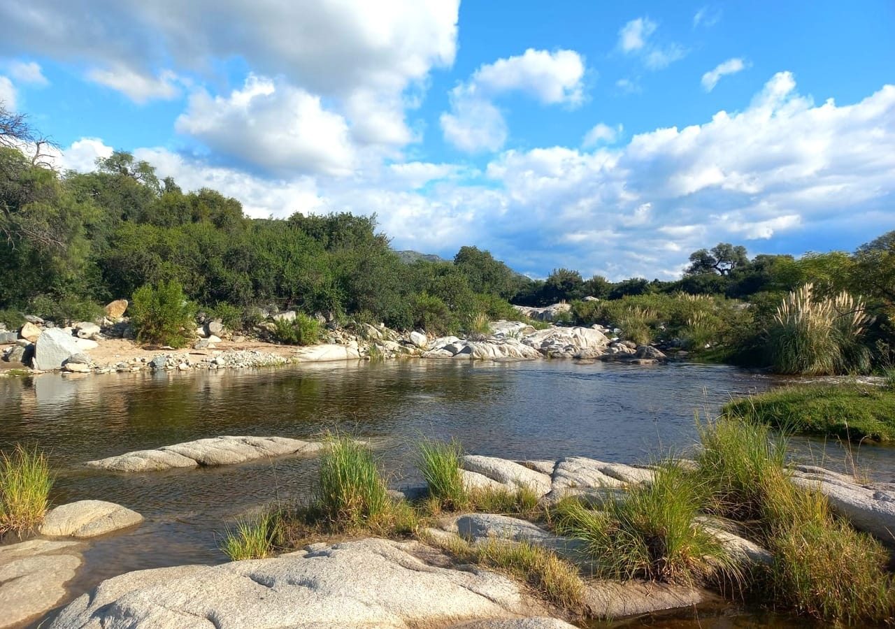 Un río de las sierras entre piedras y pastizales