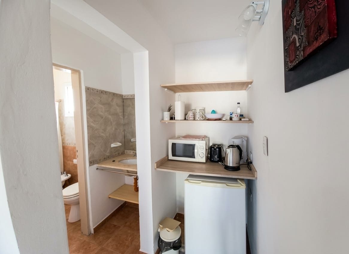 La cocina con microondas, frigobar y pava